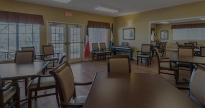 Common area of a senior living facility with tables and piano