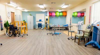 Rehabilitation therapy room with equipment and mats