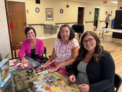 Residents engaged in a puzzle activity in a common area
