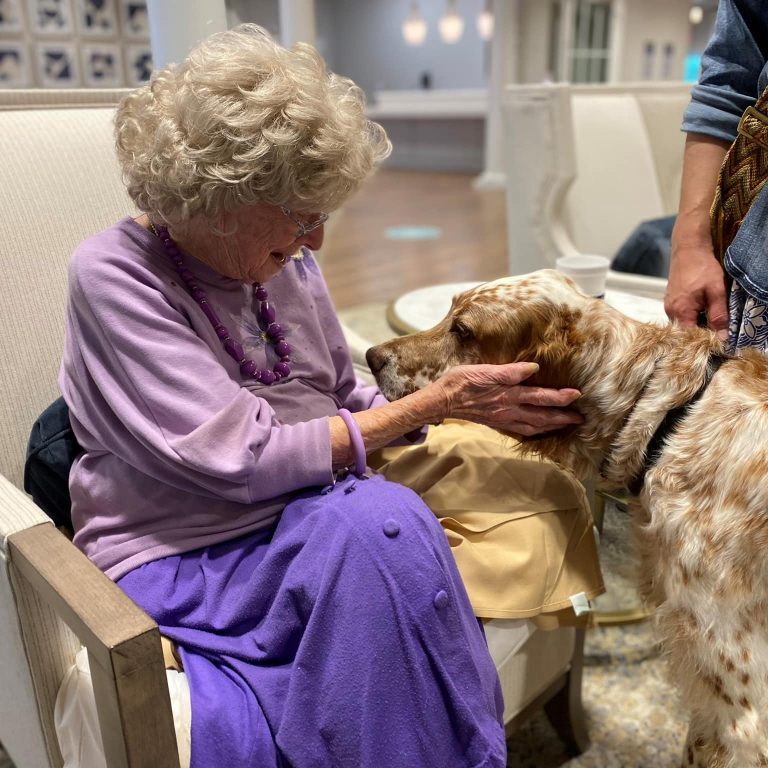 Resident interacting with a therapy dog in a common area