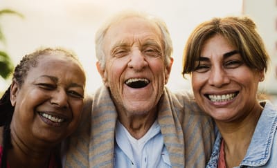 Three seniors smiling together outdoors
