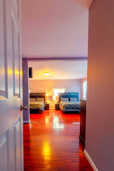 Private resident room with two beds and wooden floors