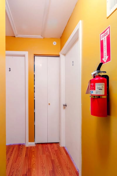 Interior hallway with numbered doors and fire extinguisher