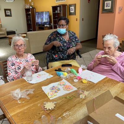 Residents engaging in a craft activity with a staff member