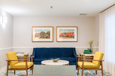 Cozy lounge area with blue couch and yellow chairs