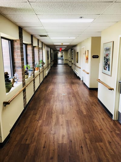Well-lit hallway with windows and artwork