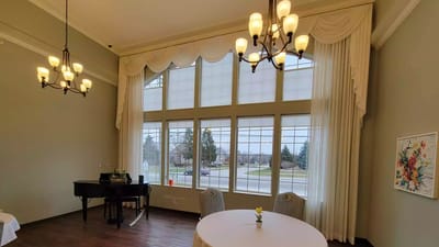 Bright common area with large windows and piano
