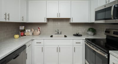 Modern kitchen space with white cabinets and appliances