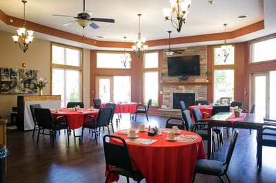 Dining area with red tablecloths and a fireplace