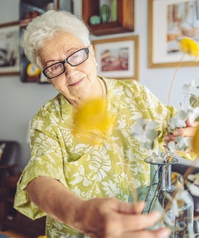 Senior resident arranging flowers in a creative activity