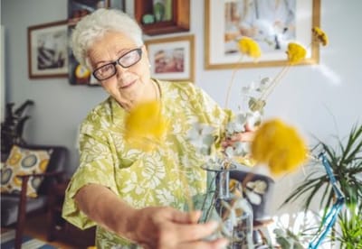 Resident arranging flowers in a bright living area
