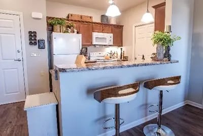 Bright kitchen area with modern appliances and bar stools