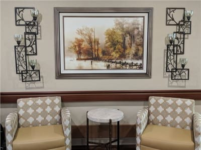 Cozy sitting area with two chairs and artwork