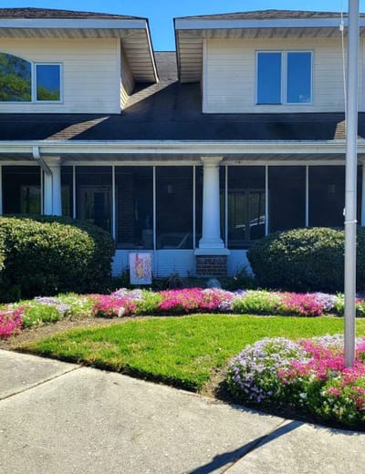 Exterior view of the facility with garden flowers