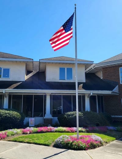 Entrance of Karolwood Gardens with flag and flowers