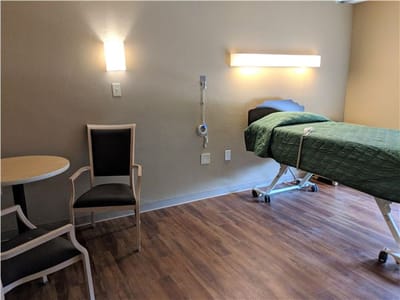 Private resident room with a hospital bed and chair
