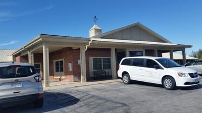 Exterior view of Jefferson City Manor with van and parking area