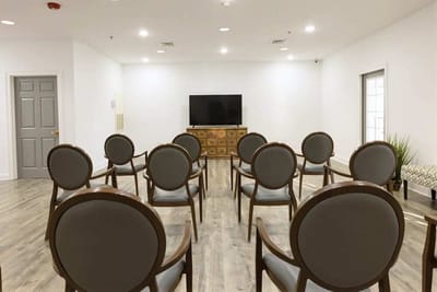 A bright, empty common area with chairs arranged