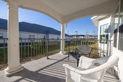 Screened patio area with seating overlooking landscaped grounds