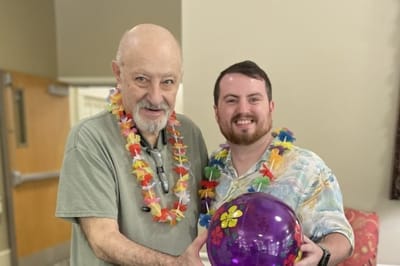 Resident and staff member holding a colorful ball