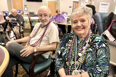 Residents enjoying an activity with festive beads