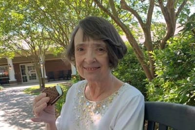 A resident enjoying an ice cream sandwich in the garden