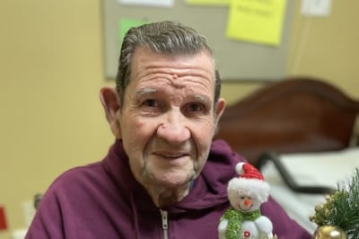 A resident smiling with a festive decoration