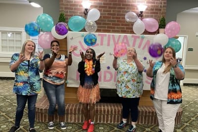 Staff and residents celebrating with balloons indoors
