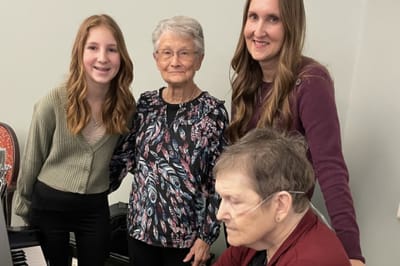Residents and staff posing together while playing music