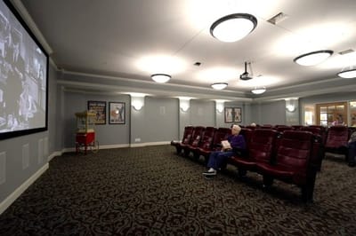 A cozy movie room with residents enjoying a film