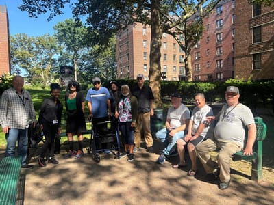 Residents and staff in a park area outside the facility