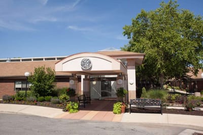 Entrance of a senior living facility with a garden