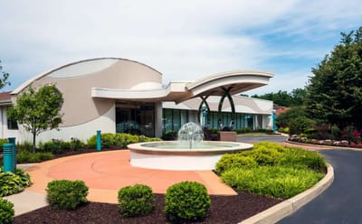 Exterior view of a senior living facility with a fountain