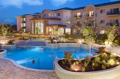 Illuminated outdoor pool with landscaped gardens