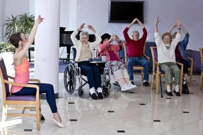 Residents participating in a seated exercise class indoors