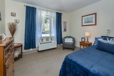Cozy interior of a private resident room with a bed and seating area