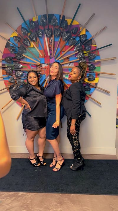 Three women posing in a colorful interior