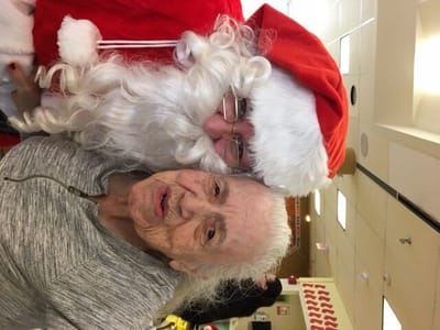 Resident poses with Santa Claus during holiday event