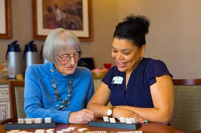 Resident and staff member engaging in a game together