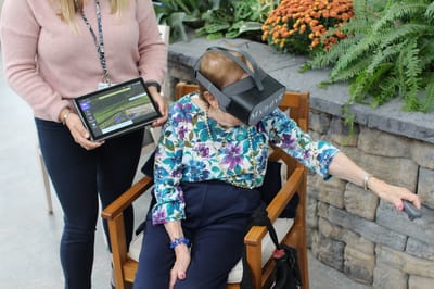 Resident using virtual reality with staff assistance