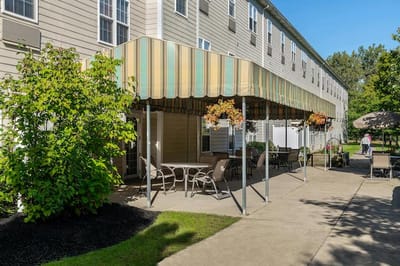Outdoor seating area with awning and greenery