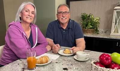 Two residents enjoying snacks together at a table.