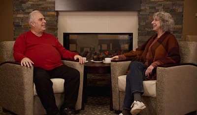 Two residents enjoying conversation in a cozy common area