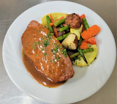 A plated meal featuring meatloaf and vegetables