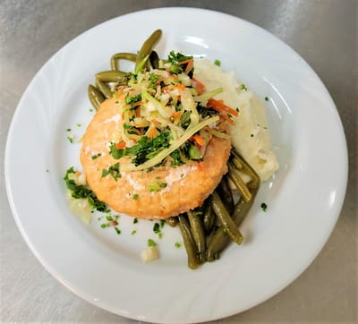 A plate of grilled salmon with vegetables and mashed potatoes