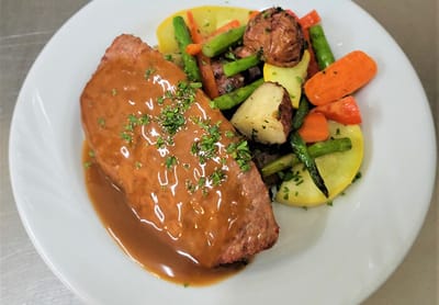 A plated meal featuring meatloaf and vegetables