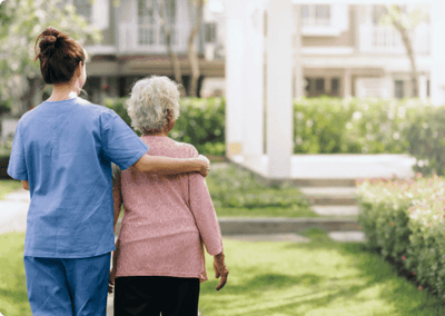 Caregiver assisting an elderly resident outdoors