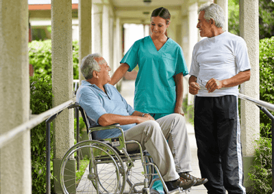 Staff interacting with residents in an outdoor pathway