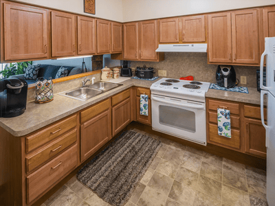 Bright kitchen area with wooden cabinets and appliances