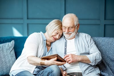 Couple enjoying a tablet together on a couch